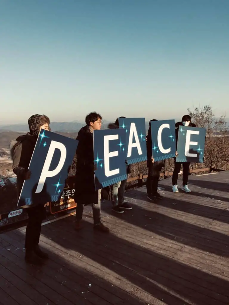 Activists hold up signs to spell 'PEACE'